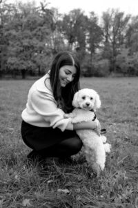 familie-stadtpark-fuerth Frau sitzt auf Wiese im Stadtpark in Fürth und spielt mit Hund.