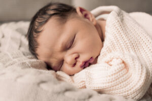 newborn-home-fotos-nuernberg Baby schläft auf einer Decke im Wohnzimmer.