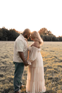 paarshooting-sonnenuntergang-Nuernberg Ein Paar steht auf einer Wiese im Sonnenuntergang und legen ihre Stirn aneinander.