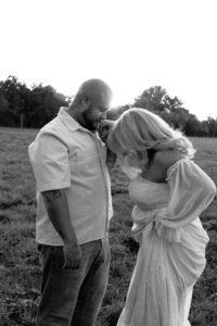 parchen-bilder-wiese-fuerth Auf einer Wiese hält ein Mann die Hand seiner Frau und küsst sie.