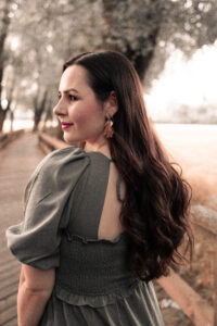 portraitbilder-wiese-fuerth Eine steht im Park, blickt nach links un lächelt.